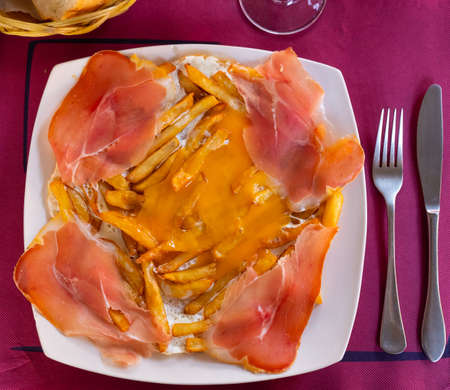 Fried eggs with fried potatoes and sliced cured hamの写真素材