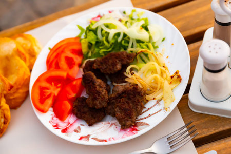 Turkish kofte, grilled veal meatballs with vegetables and bread
