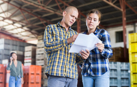 Man having conversation with young woman in warehouse