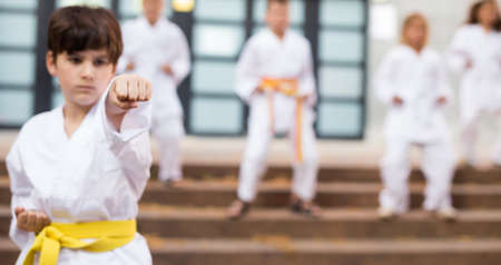Boy in kimono during training karate exercises at summer outdoorsの写真素材