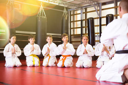Group of karate kids and trainer in gymの写真素材