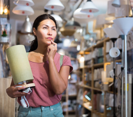 Woman with table lamp in storeの写真素材