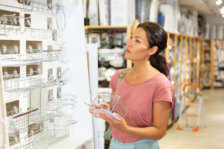 Asian woman choosing accessories for bathroomの写真素材