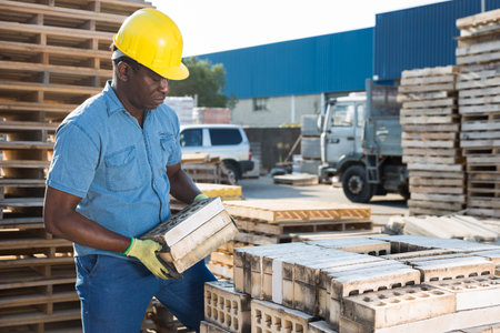 African american worker warehouse lays bricks