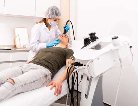 Man getting face ultrasound lifting procedureの写真素材