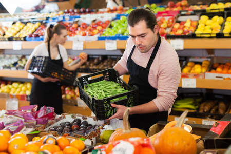 Seller with beans in greengroceryの写真素材