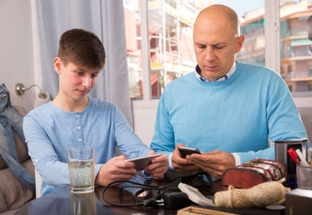 Father with son using smartphonesの写真素材