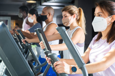 Woman training on elliptical trainer at gym