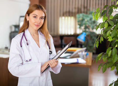 Female doctor standing in hall and smilingの写真素材