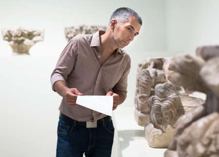 Adult male is visiting at the exposition with brochureの写真素材