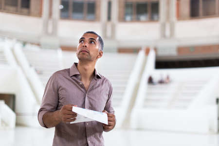 Adult male is visiting at the exposition with brochureの写真素材