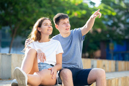 Two young people are sitting in the parkの写真素材