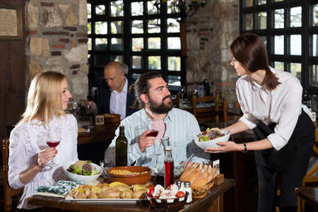 Waitress bringing meals to visitorsの写真素材