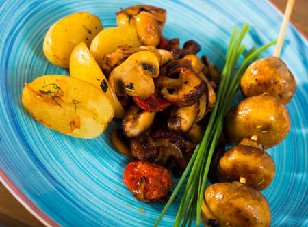 Fried shiitake, champignons and oyster mushrooms with potatoesの写真素材