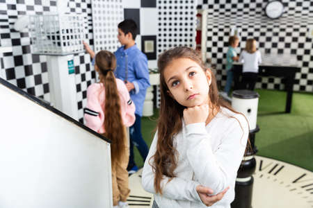 Pensive girl solving conundrum in quest room designed as chessboardの写真素材