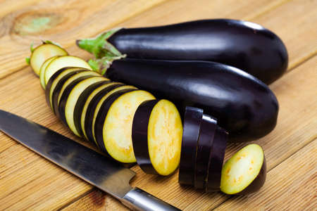 Organic eggplant on wooden cutting boardの写真素材