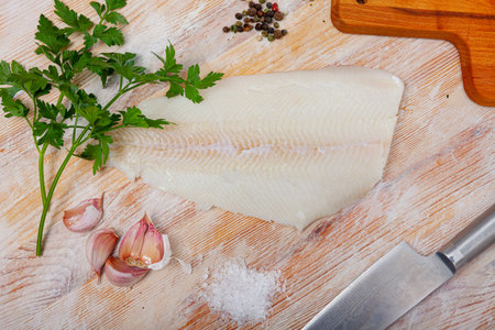 Raw halibut fillet on wooden table