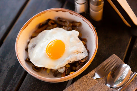 Fried egg with baked potatoes with eggplant and pepperの写真素材