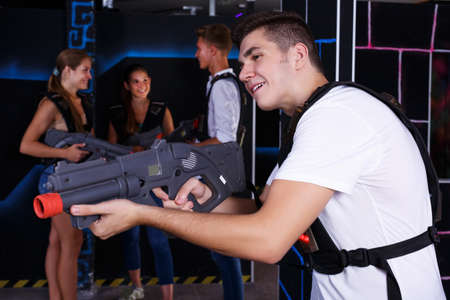 guy holding laser pistol playing laser tag gameの写真素材