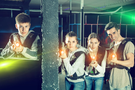 Glad young people posing with laser guns