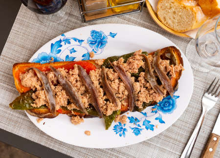 Toasted bread with chopped tuna, anchovies and baked bell pepperの写真素材