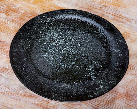 Black and white ceramic plate on wooden backgroundの写真素材