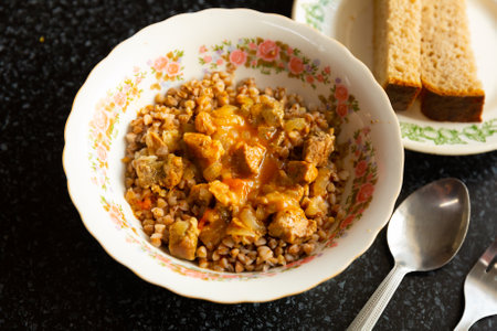 Boiled buckwheat with goulash served with bread in canteenの写真素材