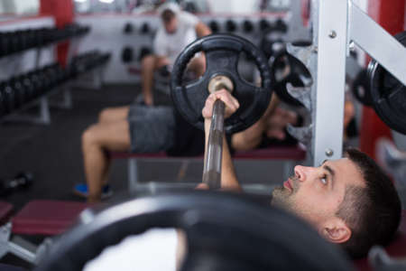 Man exercising with barbell at gymの写真素材