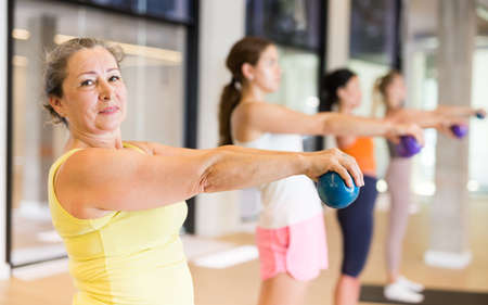 Sporty women doing exercises with pilates balls during group trainingの写真素材