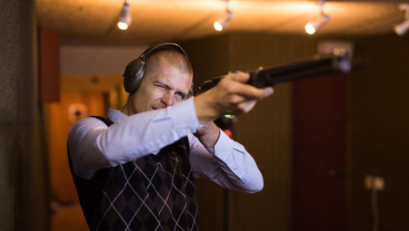 Man shoots a double-barreled gun at shooting range
