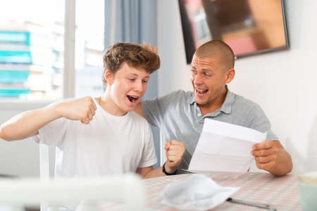 Happy father and son reading letterの写真素材