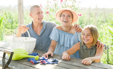 Family sitting at table in gardenの写真素材