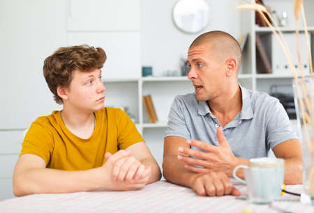 Man with his son are talking about life together at homeの写真素材