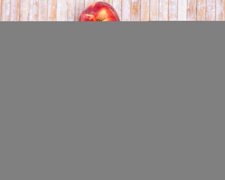 Whole and half fresh red peaches on wooden table.