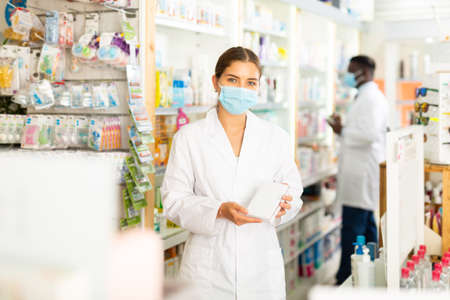 Pharmacist in mask with drug packageの写真素材