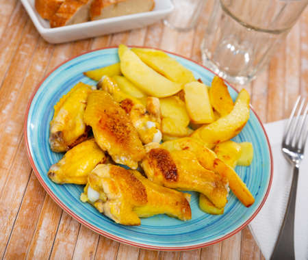 Fried barbecue chicken wings with baked potatoの写真素材