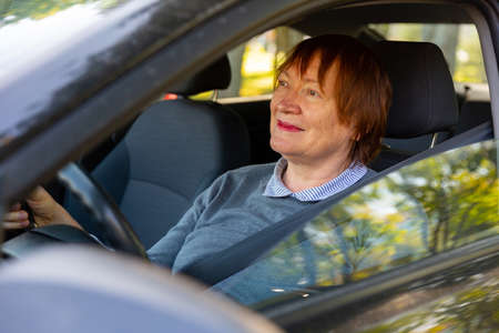 Positive mature woman sitting inside her carの写真素材
