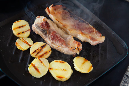 Barbecue grilled pork meat and prepared potatoes