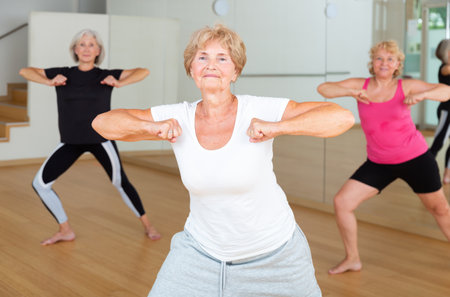 Energetic elderly woman practicing vigorous dance movementsの写真素材