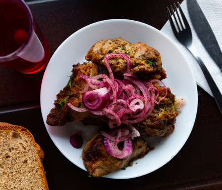 Portion of pork shashlik with greenery and onionの写真素材
