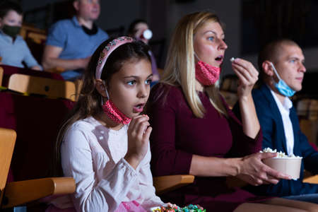 mother, her child sitting at film in auditorium during epidemicの写真素材