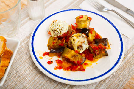 Stewed eggplant with vegetables, meatballs and cheese servedの写真素材