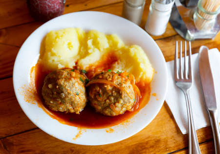 Fresh hot mashed potatoes and meatballs with gravy on plate. Russian cuisineの写真素材