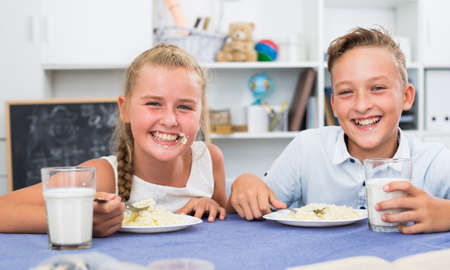 Girl and boy are eatingの写真素材