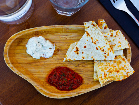 Toasted flatbread with spicy tomato sauce and garlic tomeya sauce