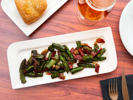 Sauteed asparagus with ham and foie chips closeupの写真素材