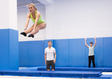 Female gymnast exercising L shape on trampoline