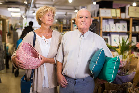 Mature couple with various goods in a shopの写真素材