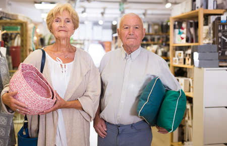 Mature couple with various goods in a shopの写真素材