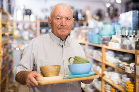 Senior man choosing variety goods for kitchenの写真素材